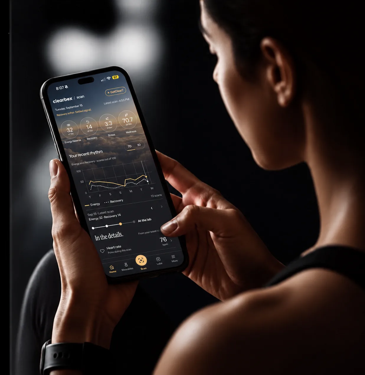 A patient holding a phone showing the GetClear home screen.